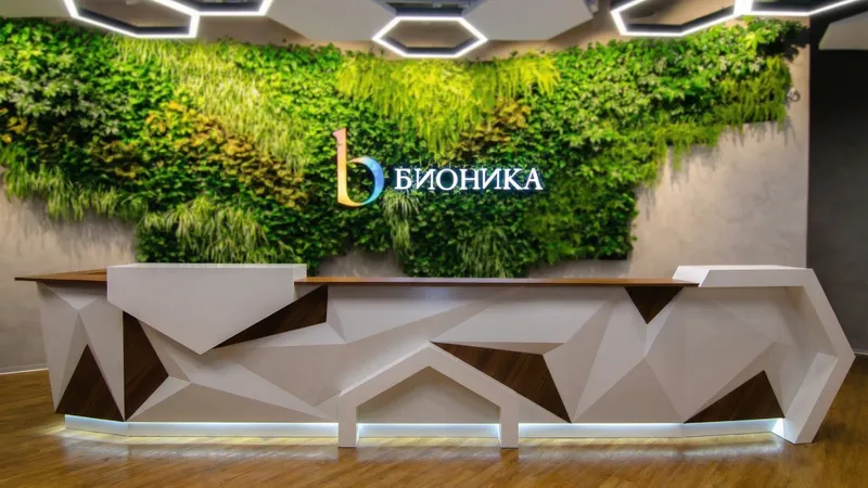Стойка РИ-199 - вид в интерьере Длинная стойка ресепшн РИ-199 в современном офисном интерьере с зеленой фитостеной.