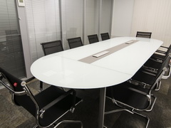 Стеклянный стол переговоров овальной формы на 10человек со столешницей из белого стекла и встроенными розетками