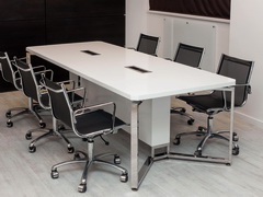 Белый стол переговоров в офисе, столешница белый искусственный камень, опоры нержавеющая сталь, стол оборудован розетками