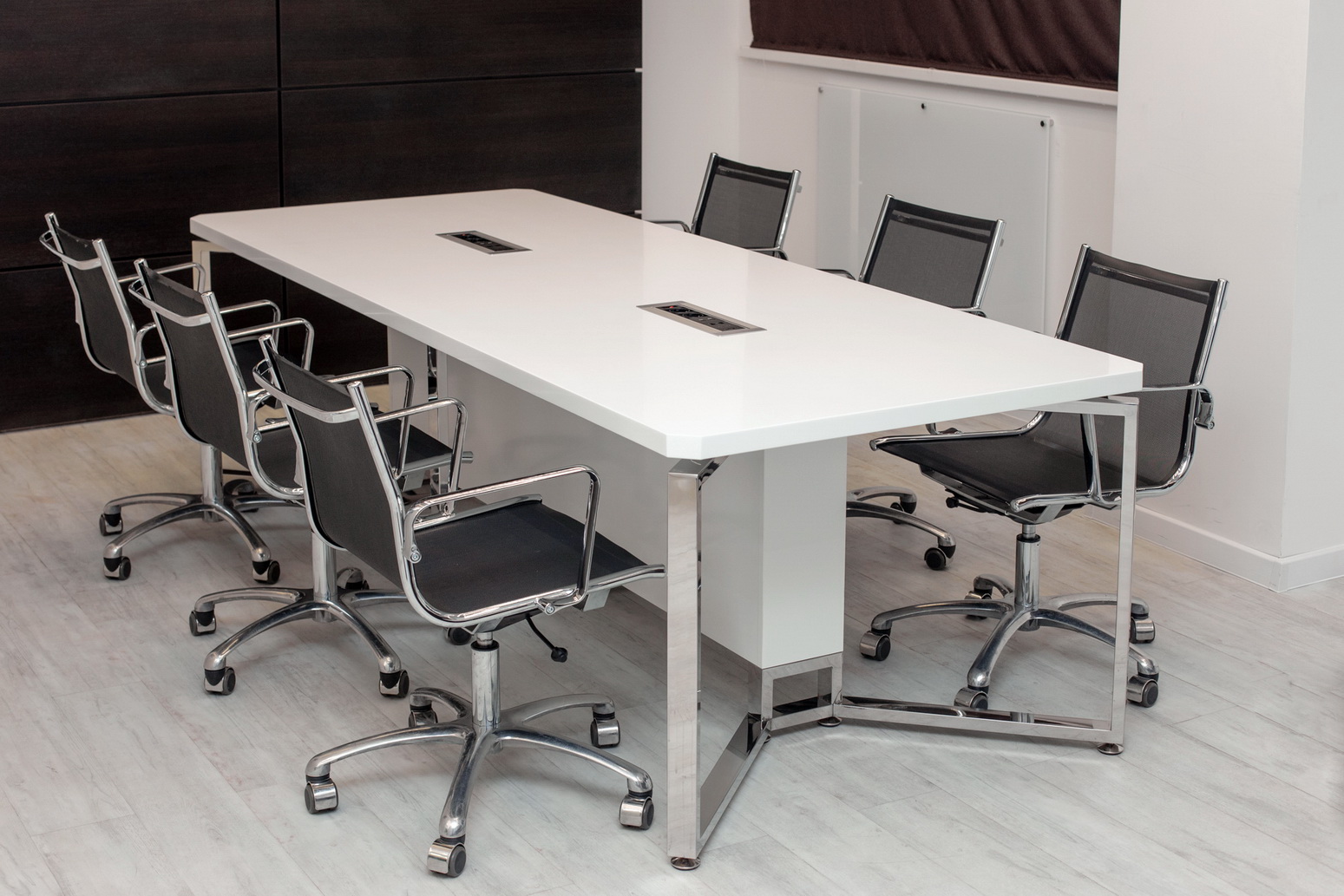 Белый стол переговоров в офисе, столешница белый искусственный камень, опоры нержавеющая сталь, стол оборудован розетками