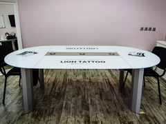 Белый стол переговоров с логотипом и встроенным блоком розеток